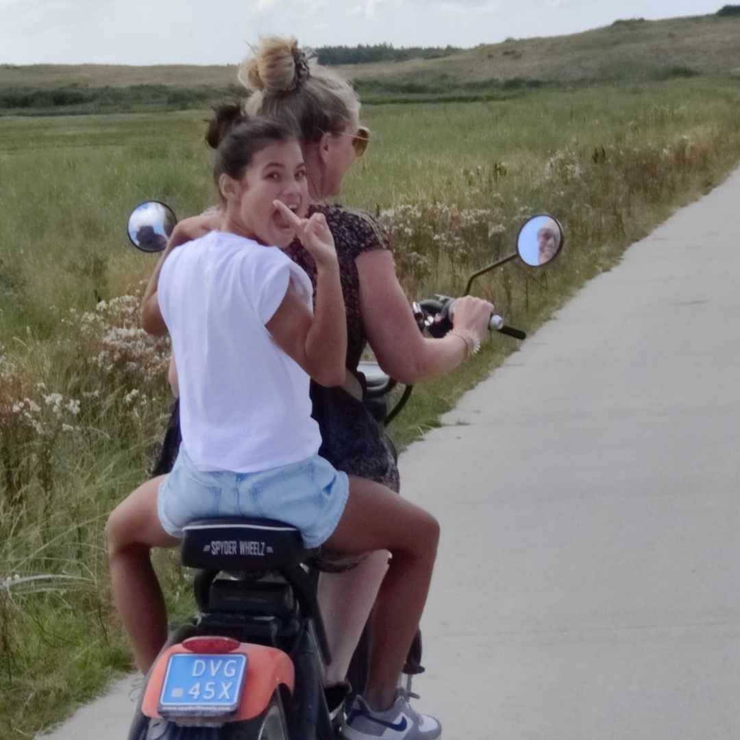 Twee personen op een e-chopper op een pad langs de heide.